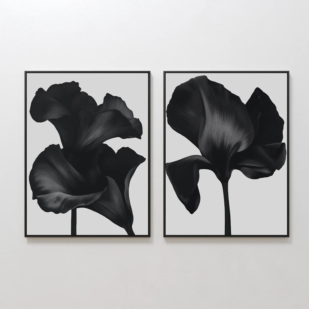 The Noir Bloom Set of 2 features framed black floral prints, each showcasing a close-up dark abstract bloom on a light gray background—contemporary wall art that brings bold elegance to any room.