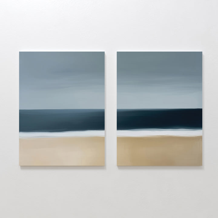 The Ocean Edge Set of 2 features square paintings with a minimalistic seascape—sandy beach, deep blue ocean, and cloudy sky in soft brushstrokes—perfect for serene coastal decor in your living room.