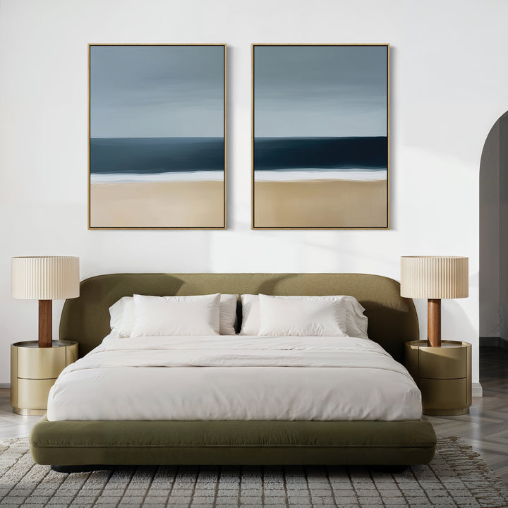 Modern bedroom featuring an olive green bed with white bedding, beige nightstands with matching lamps, a textured rug, and the Ocean Edge Set of 2 coastal wall art above the bed on a white wall.