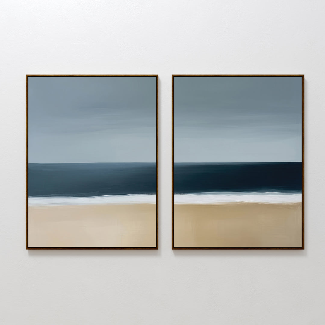The Ocean Edge Set of 2 features framed abstract paintings in soft blue, gray, and beige, capturing the sky, sea, and beach for calming coastal wall art—ideal for serene living room decor.