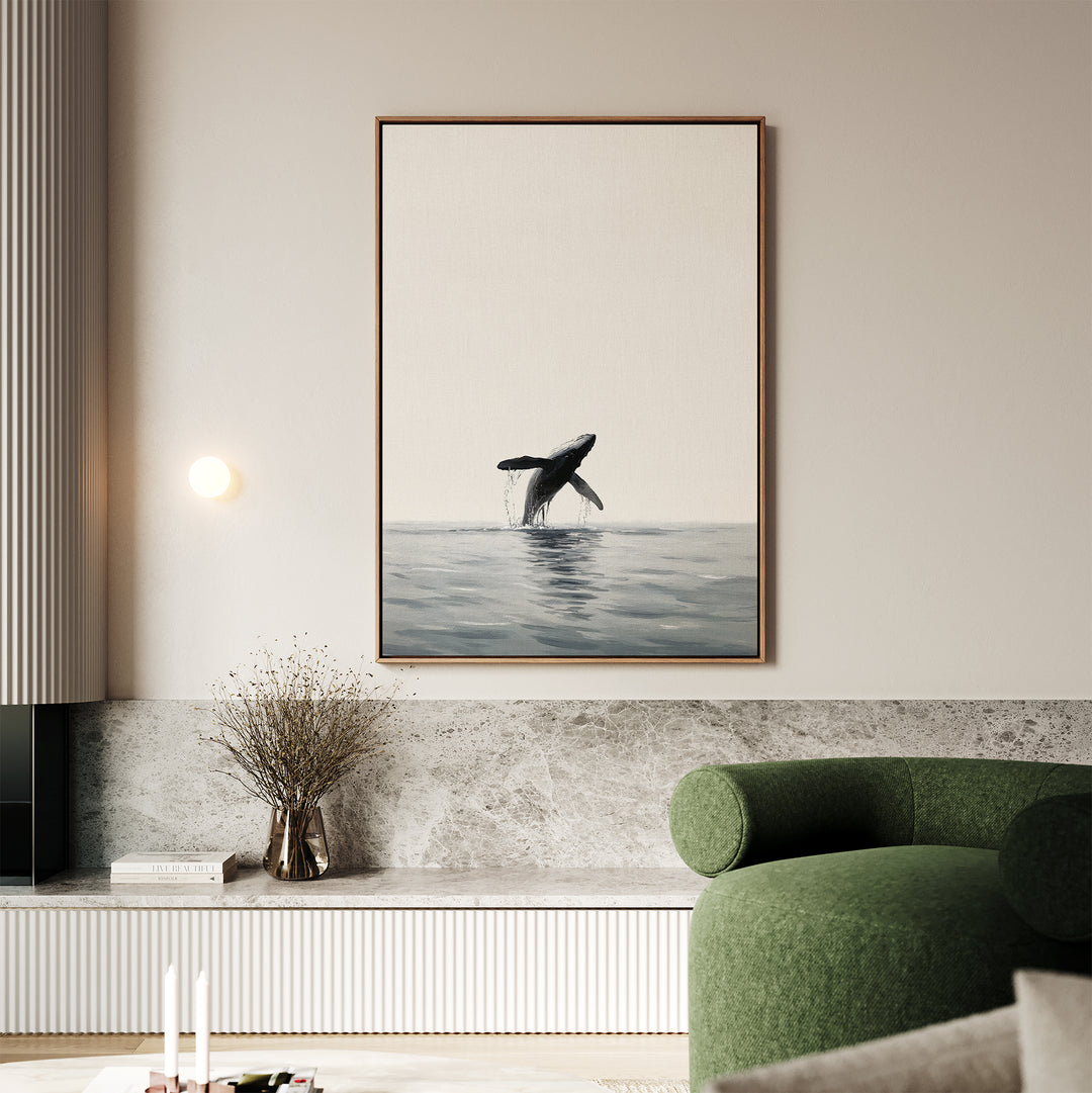 A modern living room features a green curved sofa, a marble shelf, and the Ocean Leap Canvas Art depicting a whale breaching above calm water. Minimalist decor and soft lighting complete the cozy atmosphere.