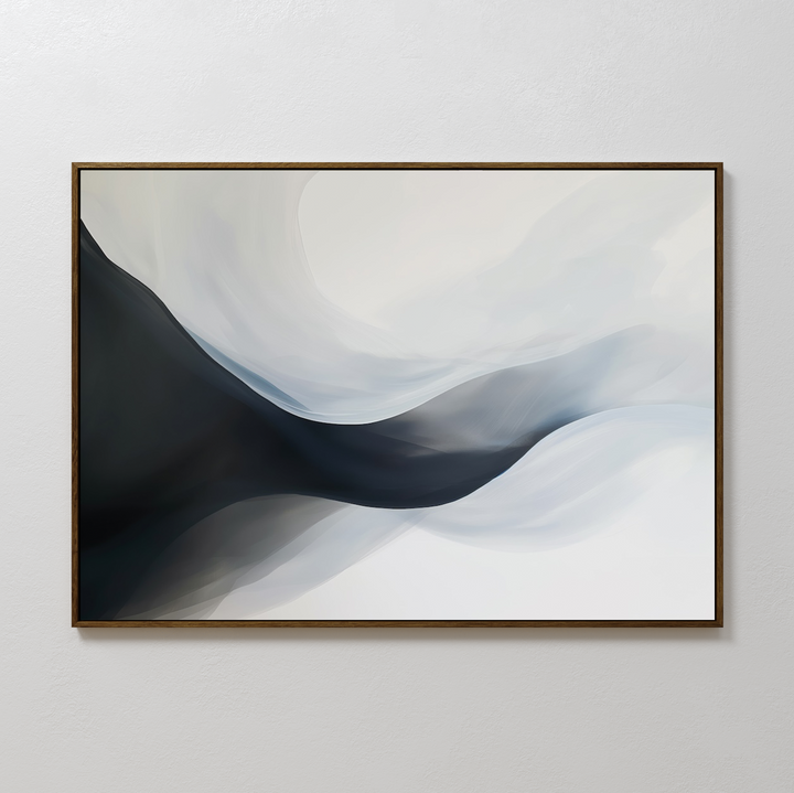Rippling Vista Abstract Canvas Art features smooth, flowing shapes in black, gray, and white, evoking misty waves or mountains. This minimalist piece comes framed in a thin, dark frame and is ideal for display on a plain white wall.