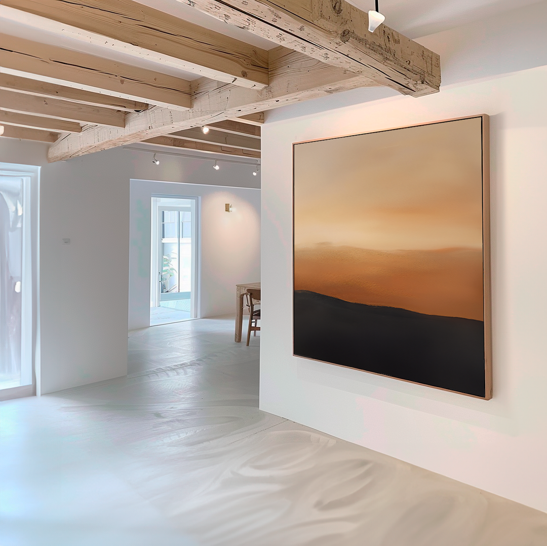 A modern room with wooden ceiling beams features the Tranquil Vista Abstract Canvas Art in warm orange and dark brown hues. Sunlight streams in, highlighting the bright, minimalist living room decor.