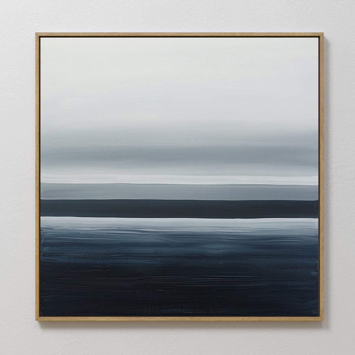 Oceanic Blur Abstract Canvas Art features horizontal layers of white, gray, and dark blue in a gold frame, blending together for a serene coastal look. Perfect minimalist wall art to enhance your living room decor with a tranquil atmosphere.