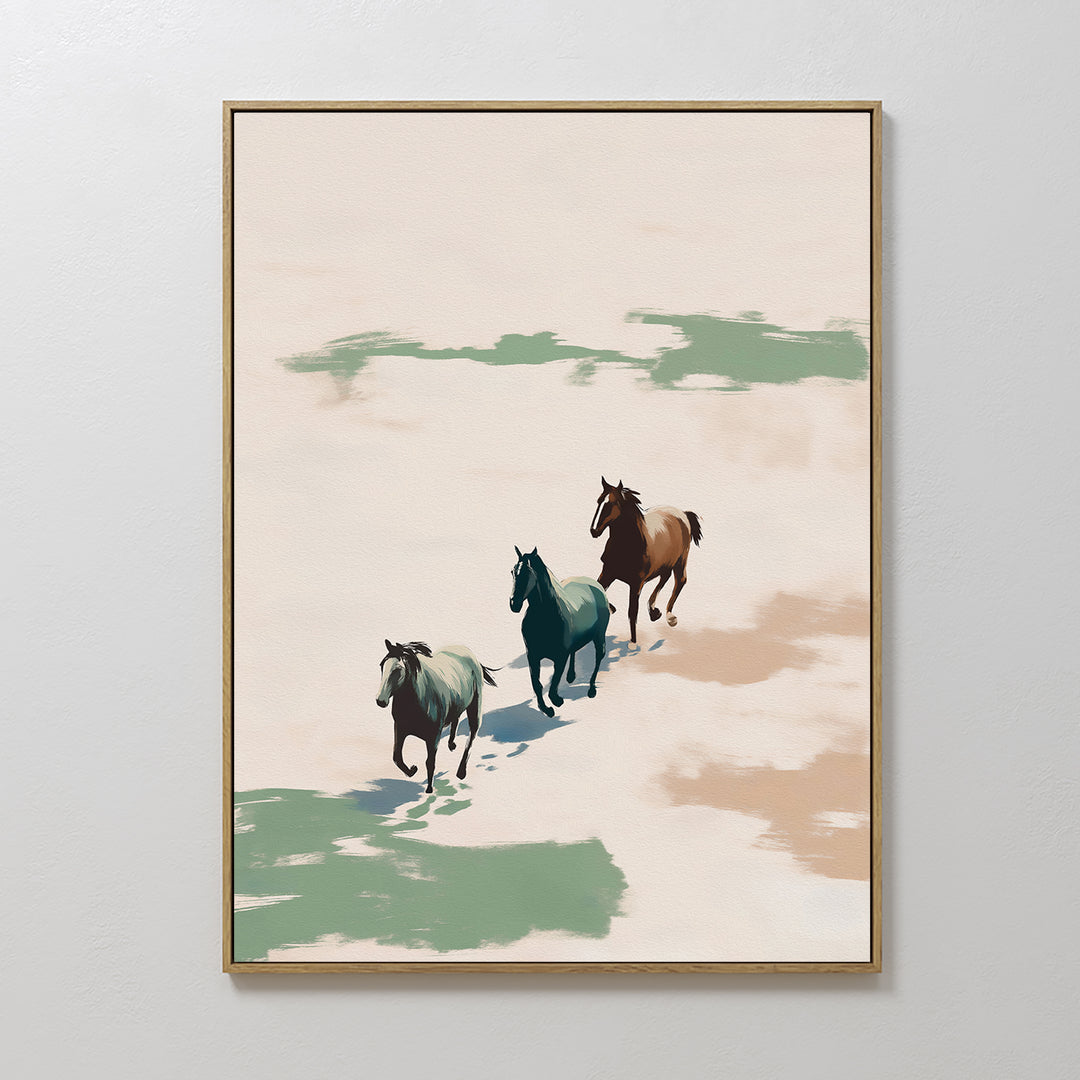 The Running Free Canvas Art features three horses galloping side by side over sandy ground with green and brown patches, set against a light, neutral background in a minimalist style.