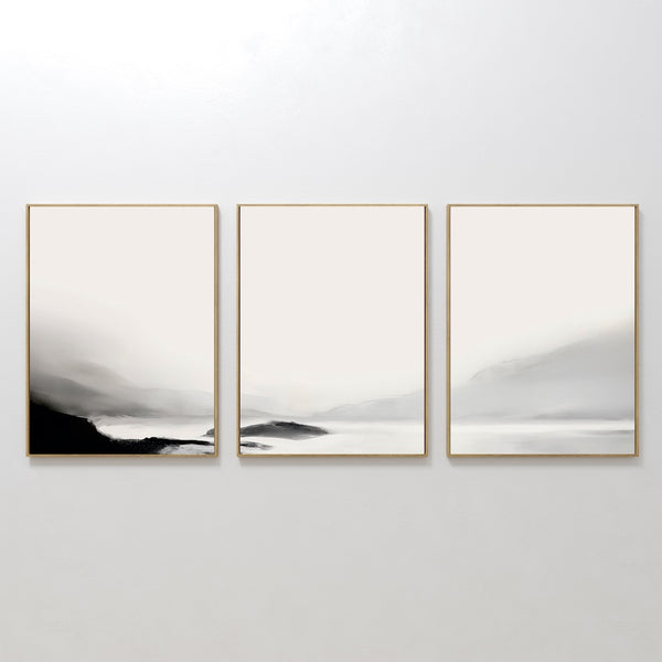 The Serenity Peaks Set of 3 is a minimalist triptych with soft, muted gradients of white, gray, and black. This abstract landscape evokes misty mountains or foggy hills for a serene, elegant touch to your home decor.