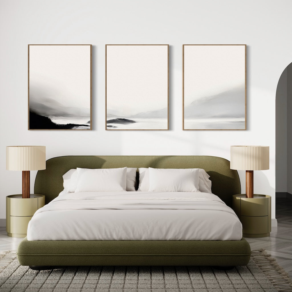 Minimalist bedroom with an olive green bed, white bedding, two beige lamps on matching nightstands, and the Serenity Peaks Set of 3 abstract landscape paintings in neutral tones above the bed for a serene, modern look.