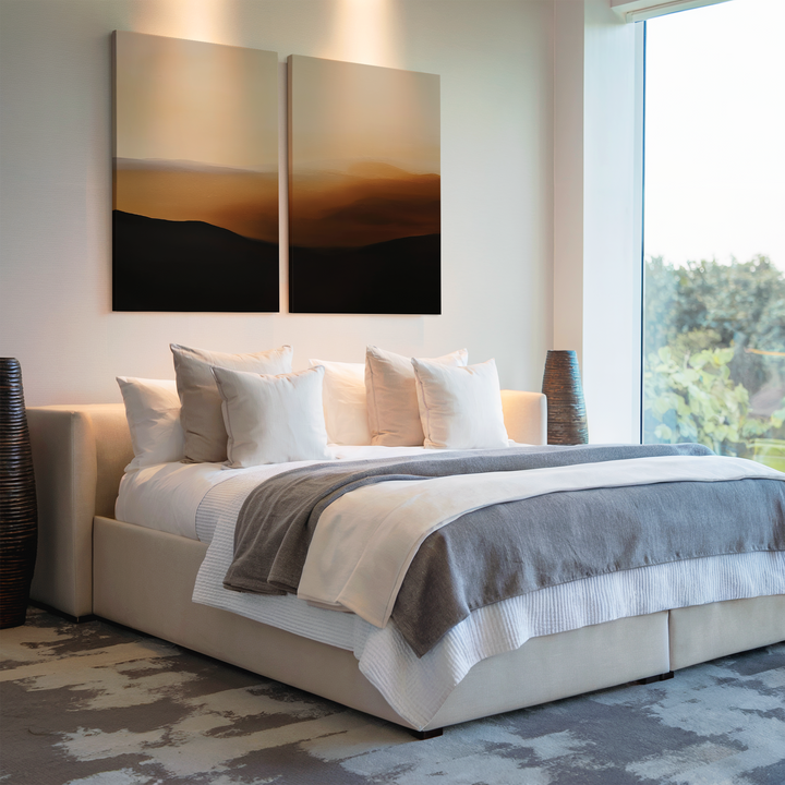 A modern bedroom with a large bed with white and gray bedding, several pillows, Sienna Echo Set of 2 wall art above the headboard, floor vases on each side, and a large window letting in natural light.