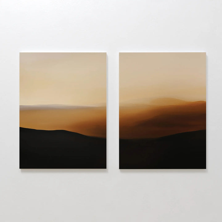 The Sienna Echo Set of 2 features abstract landscapes in soft beige, brown, and black tones, evoking a misty horizon. Ideal minimalist wall art to elevate your living room decor against a plain white wall.