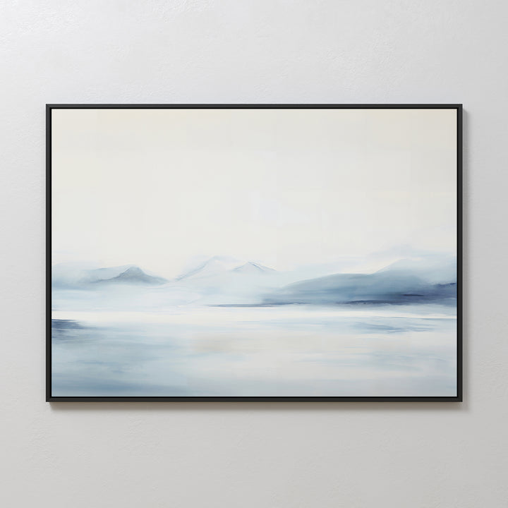 Silent Glaciers Canvas Art features minimalist blue and gray tones, depicting a serene landscape of misty mountains and calm water. This artwork comes framed in black, adding a tranquil touch to any light-colored wall.