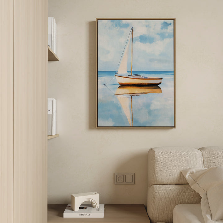 The Skybound Reflection Canvas Art, featuring a minimalist sailboat on calm water, hangs above a cream sofa in a modern living room. A low shelf with books and a white sculpture enhances the tranquil atmosphere.