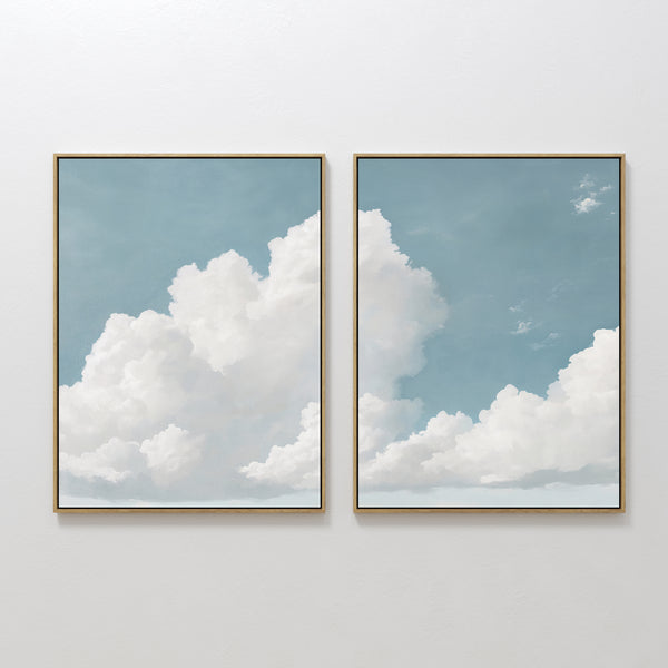 The Soaring Peace Set of 2 features framed prints of a blue sky and fluffy white clouds, bringing a calm and serene touch to any plain white wall.