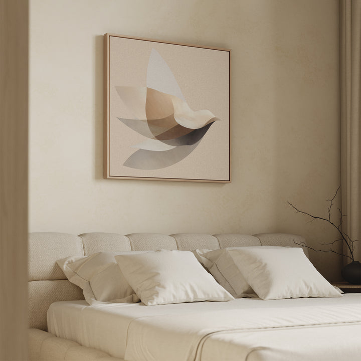 A minimalist bedroom with a beige bed and cushions, featuring the Soaring Stillness Canvas Art—a large abstract bird design in neutral tones above the headboard. A bare branch rests in a vase on the right side.