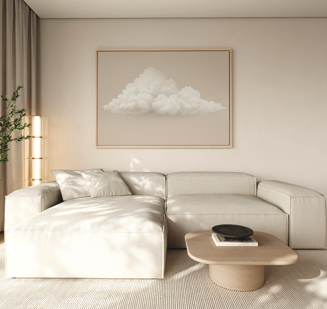 A minimalist living room with a light beige sectional, wooden coffee table, Soft Drift Canvas Art on the wall, and neutral decor bathed in soft natural light from the left, creating a serene space with subtle neutral tones throughout.