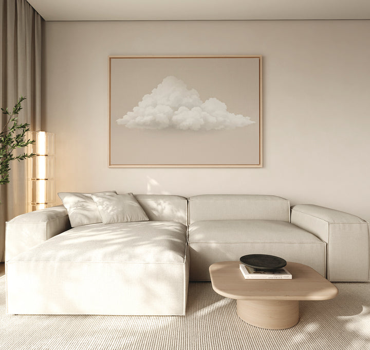 A minimalist living room with a light beige sectional, wooden coffee table, Soft Drift Canvas Art on the wall, and neutral decor bathed in soft natural light from the left, creating a serene space with subtle neutral tones throughout.