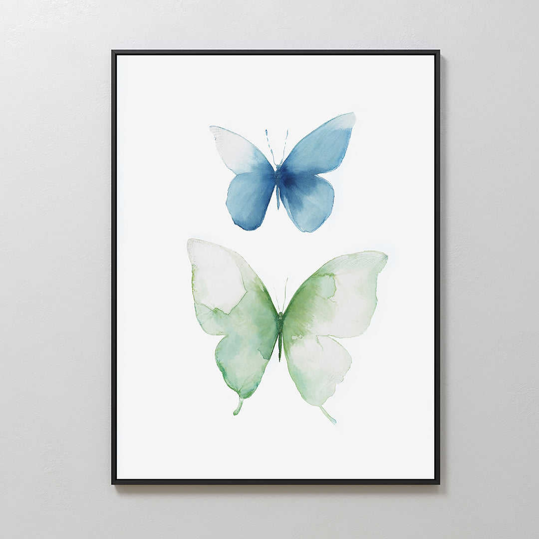 Soft Flight Canvas Art: A minimalist framed artwork showcasing two watercolor butterflies, one blue and one green, on a white background—Nordic Park-inspired elegance for your wall.