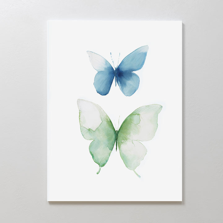 The Soft Flight Canvas Art is a minimalist wall print from Nordic Park, showcasing two watercolor butterflies—one in calming blue above and one in serene green below—set against a crisp white background.