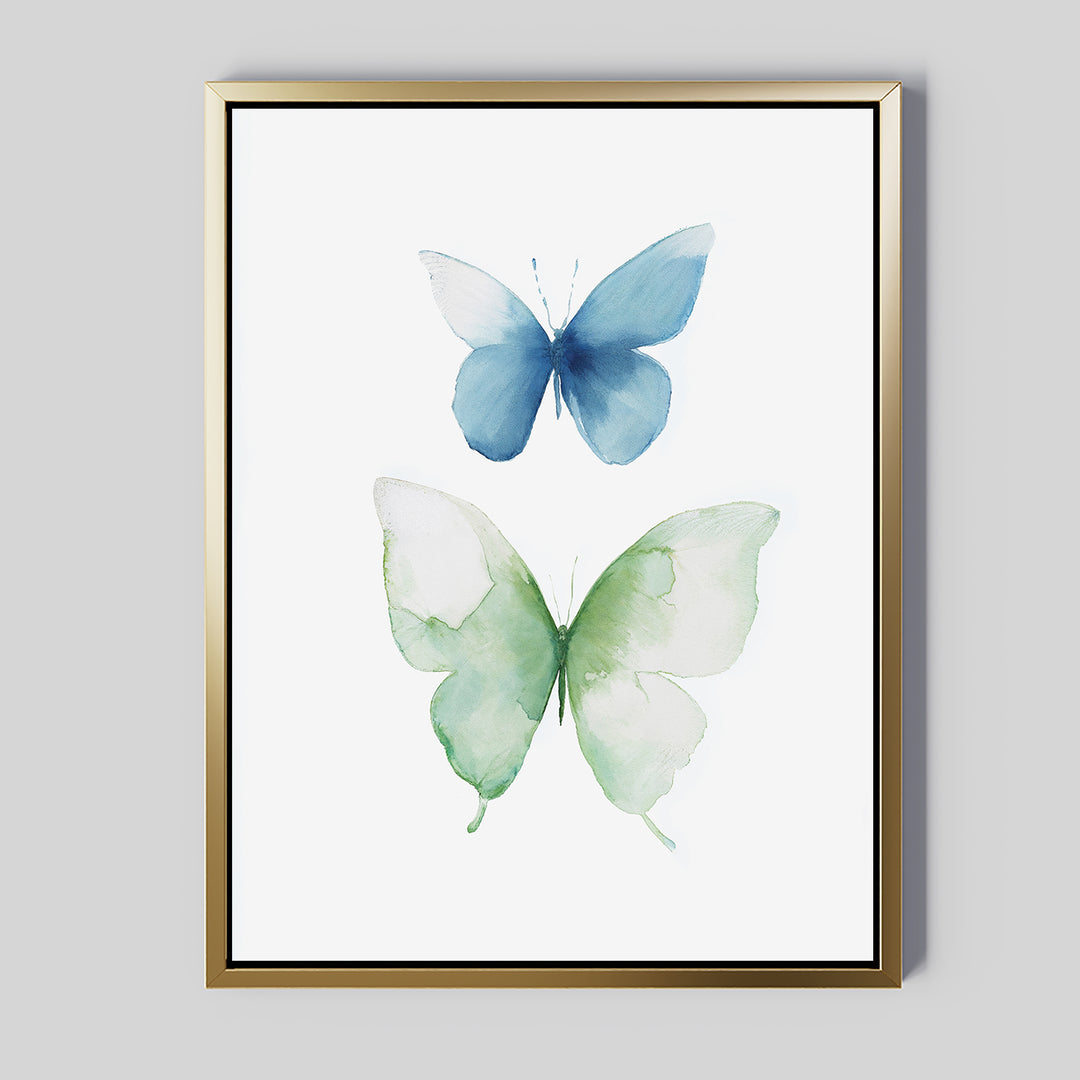 Soft Flight Canvas Art: Minimalist wall art featuring two watercolor butterflies—one blue, one green—on a white background. Inspired by Nordic parks and elegantly presented in a thin gold frame.