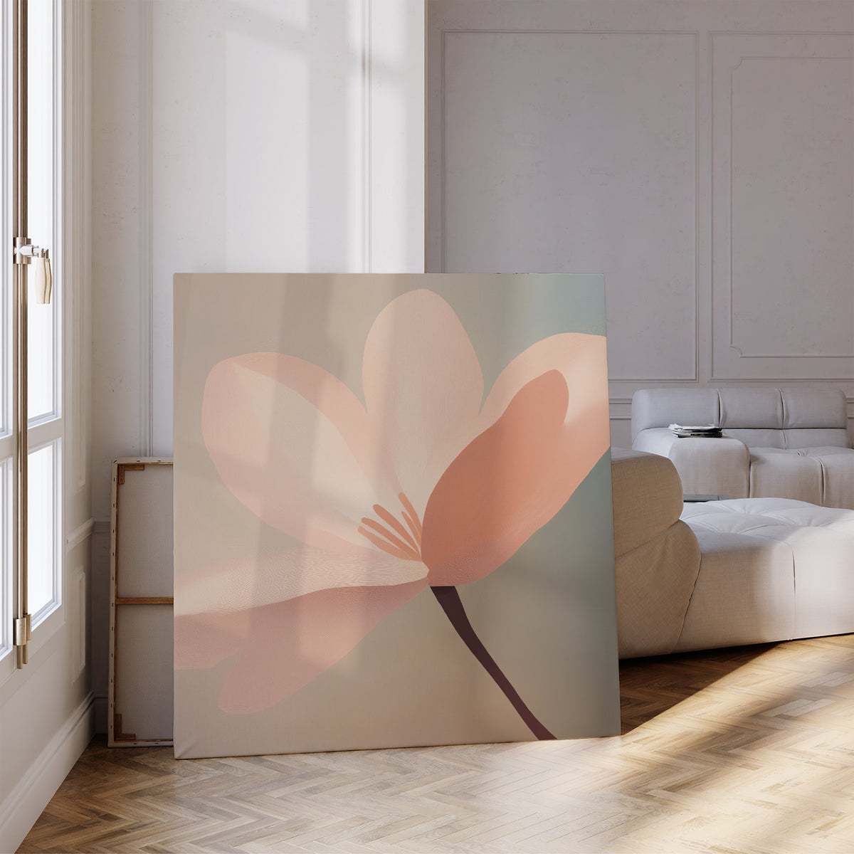 The Soft Pink Glow Canvas Art leans against the wall in a bright, modern living room with parquet floors and a white sofa. Sunlight pours through tall windows, highlighting the elegant minimalist floral design.