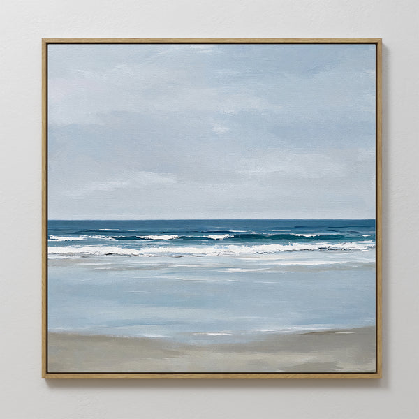 The Soft Tide Canvas Art features a serene beach scene with gentle waves and a calm sea in soft blue, white, and beige tones, making it the perfect coastal decor for any white wall.
