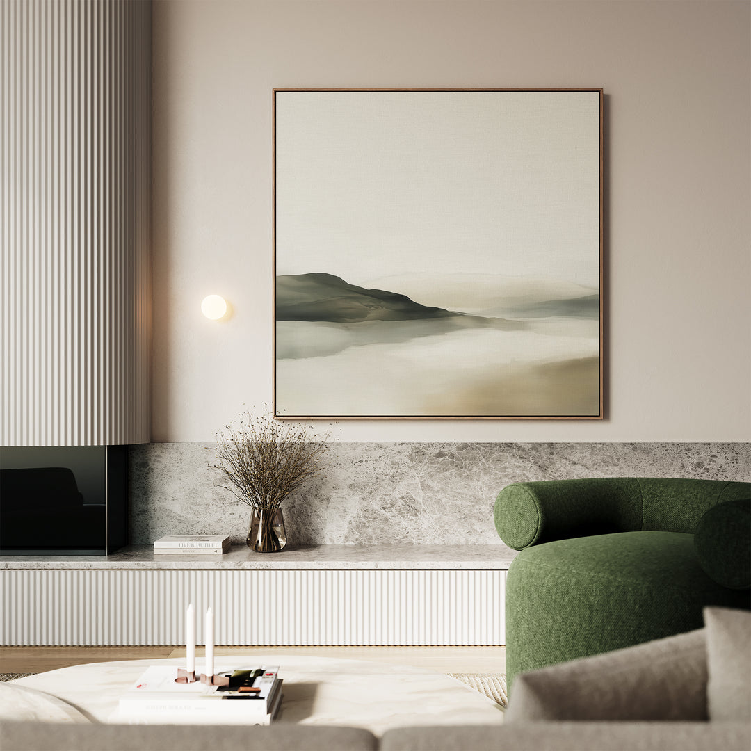 A modern living room featuring Soft Valley Canvas Art, a green upholstered chair, marble surfaces, a vase with dried branches, and candles on a low table. Neutral tones and minimalist decor create a calming atmosphere.