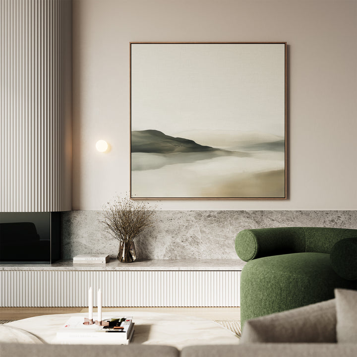 A modern living room featuring Soft Valley Canvas Art, a green upholstered chair, marble surfaces, a vase with dried branches, and candles on a low table. Neutral tones and minimalist decor create a calming atmosphere.