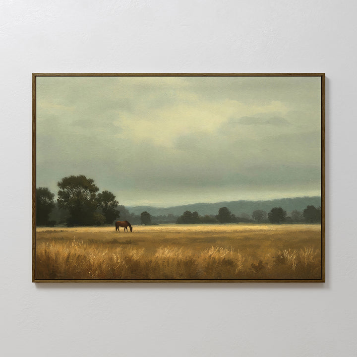 The Still Morning Canvas Art shows a horse grazing in a golden field beneath a cloudy sky with distant hills and trees—ideal countryside wall art to bring Nordic Park-inspired charm to your space.