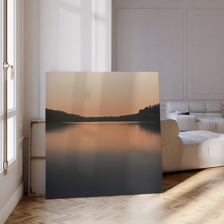 The Still Waters Canvas Art, a large framed print of a serene sunset lake, adds peaceful vibes to your living room decor—ideal for bright modern spaces with a white sofa and wooden floor.