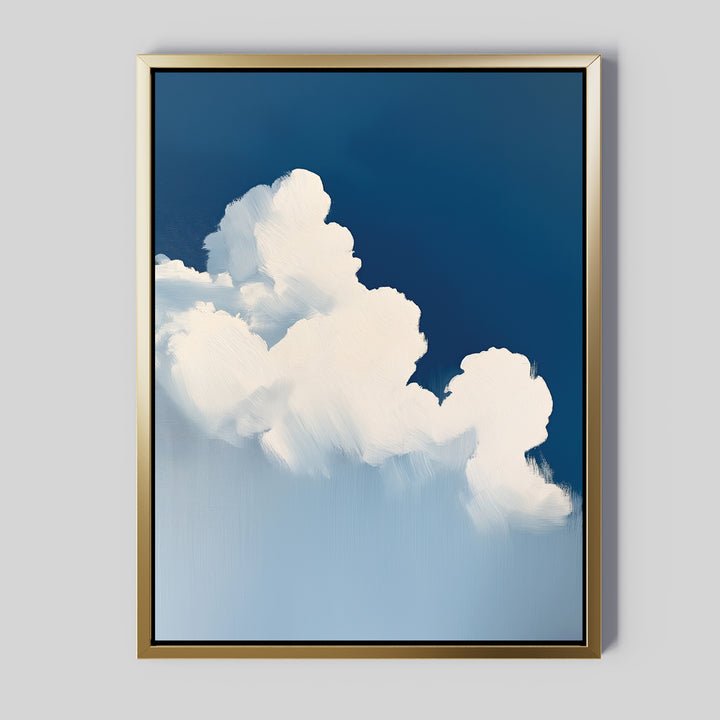 The Cumulus Abstract Canvas Art displays fluffy white clouds on a deep blue sky with soft, serene brushstrokes. This minimalist wall art includes a gold frame and is set against a light gray background for a modern look.