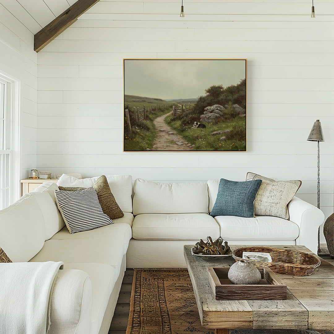 A bright, cozy living room with a white sectional sofa, neutral pillows, a rustic wooden coffee table, and The Watchful Path Canvas Art depicting a scenic path displayed on a white shiplap wall.