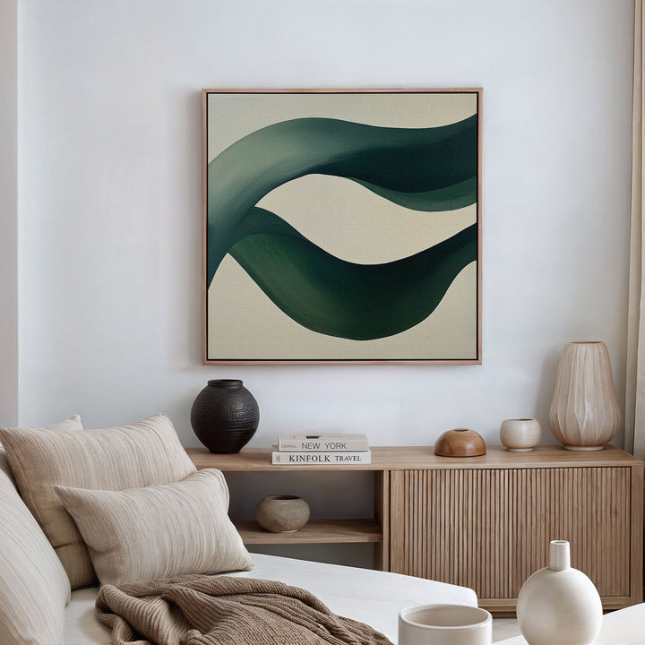 A modern living room with neutral tones features a beige sofa with cushions, a wooden sideboard with vases and books, and the Tidal Grace Canvas Art adding a vibrant touch to the space.