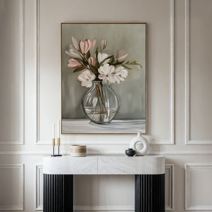 The Vase & Grace Canvas Art, featuring white and blush flowers in a glass vase, adds an elegant minimalist touch above a marble console styled with candles and decor—perfect for refined living room spaces.