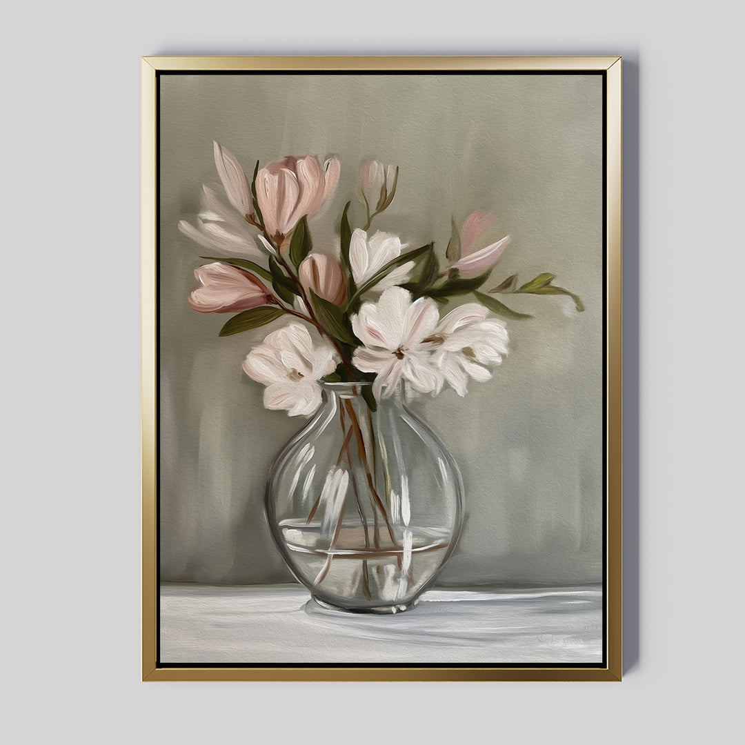 The Vase & Grace Canvas Art features white and blush flowers in a clear vase on a crisp white surface, set against a muted green background in a gold frame—ideal minimalist wall art for elegant living room decor.