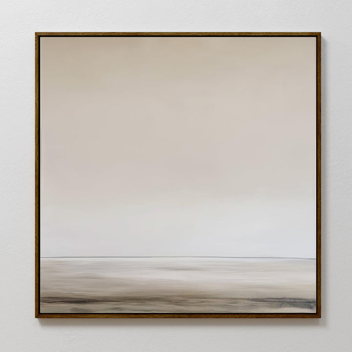 The Morning Mist Abstract Canvas Art features a minimalist landscape in soft beige and gray tones, with a hazy horizon in a thin, dark frame—offering modern elegance through its smooth gradient sky and muted, flat foreground.