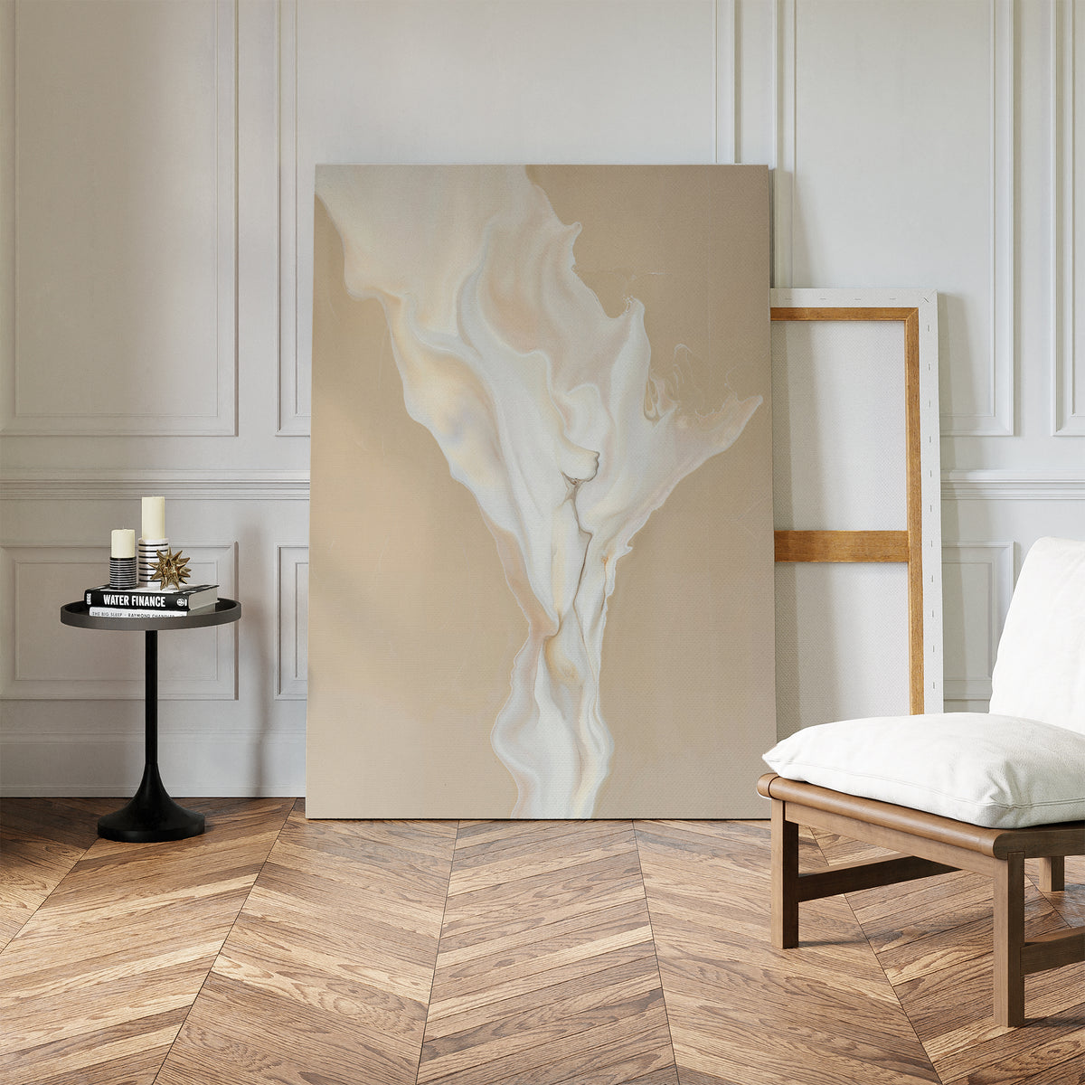 A minimalist living space with herringbone wood floors features the White Flame Abstract Canvas Art leaning against the wall, a black side table with candles, an empty frame, and a white cushioned chair.