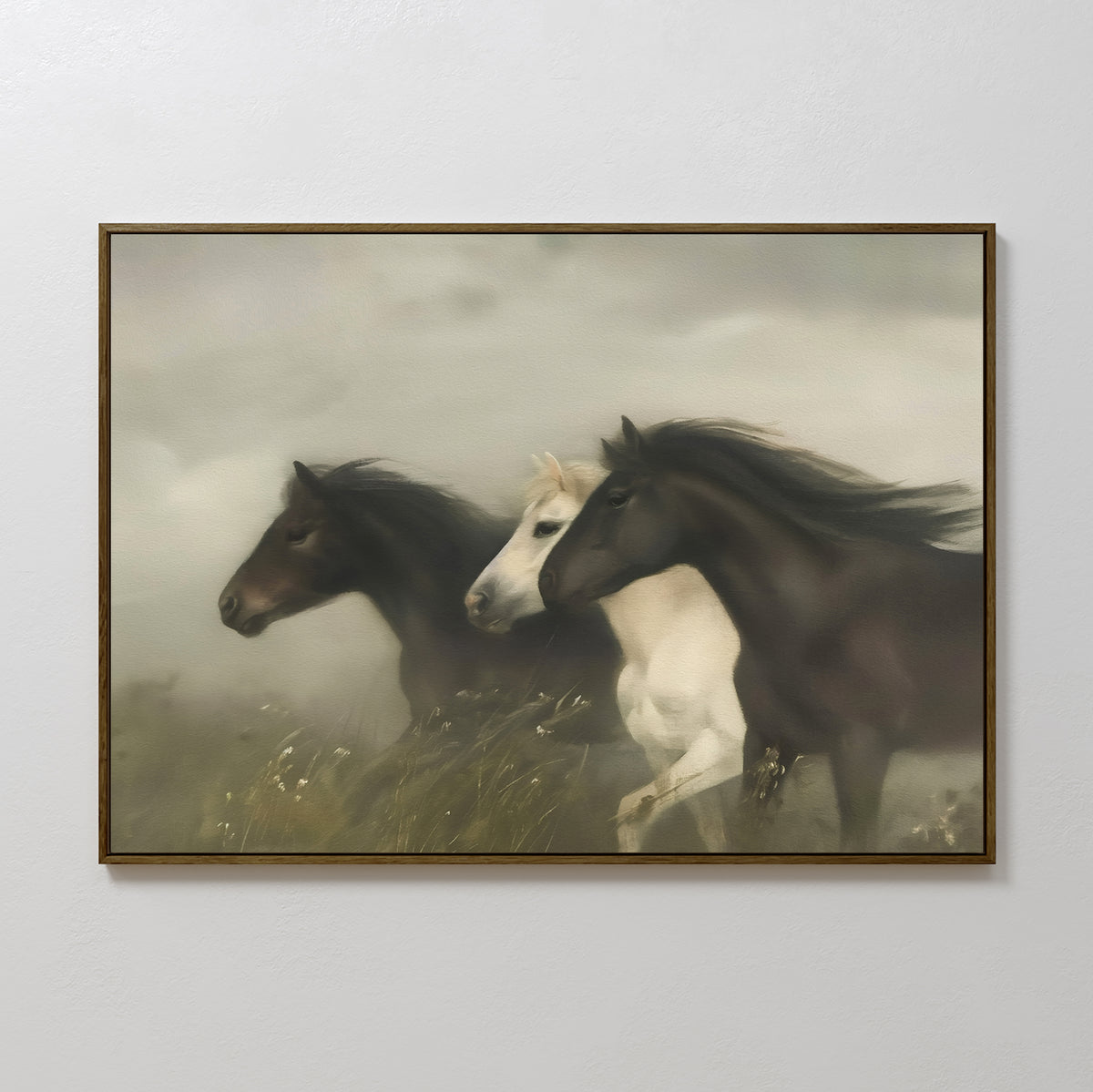 The Wild Current Canvas Art features three horses—two dark brown and one white—running side by side through tall grass against a misty background. This large, framed wall art makes a striking addition to any room.