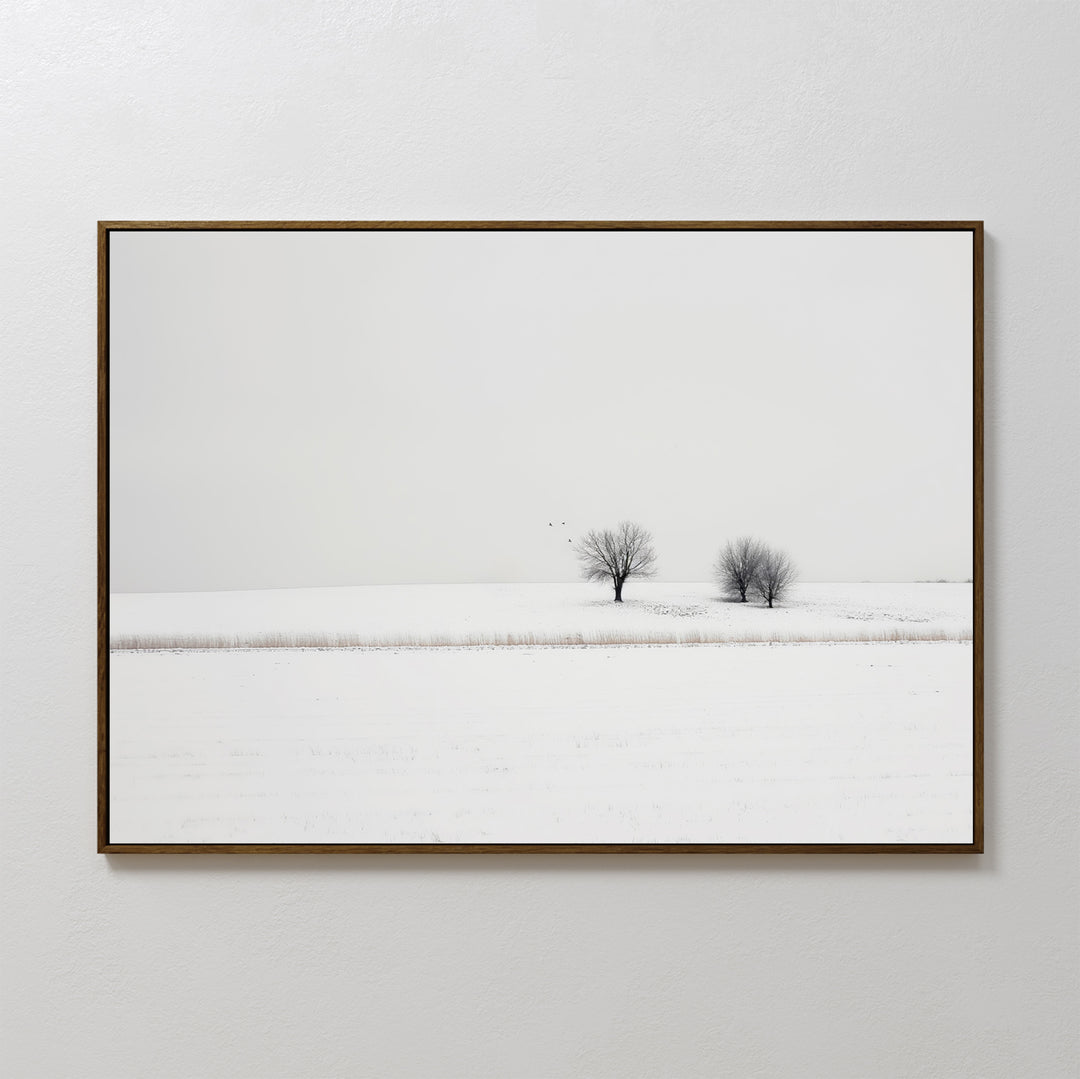 Winter Silence Canvas Art features a minimalist photograph of two bare trees in a snowy landscape beneath a pale sky—an elegant choice for winter wall decor.