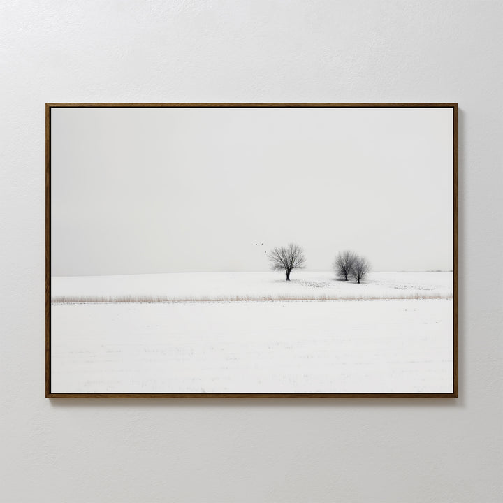 Winter Silence Canvas Art features a minimalist photograph of two bare trees in a snowy landscape beneath a pale sky—an elegant choice for winter wall decor.