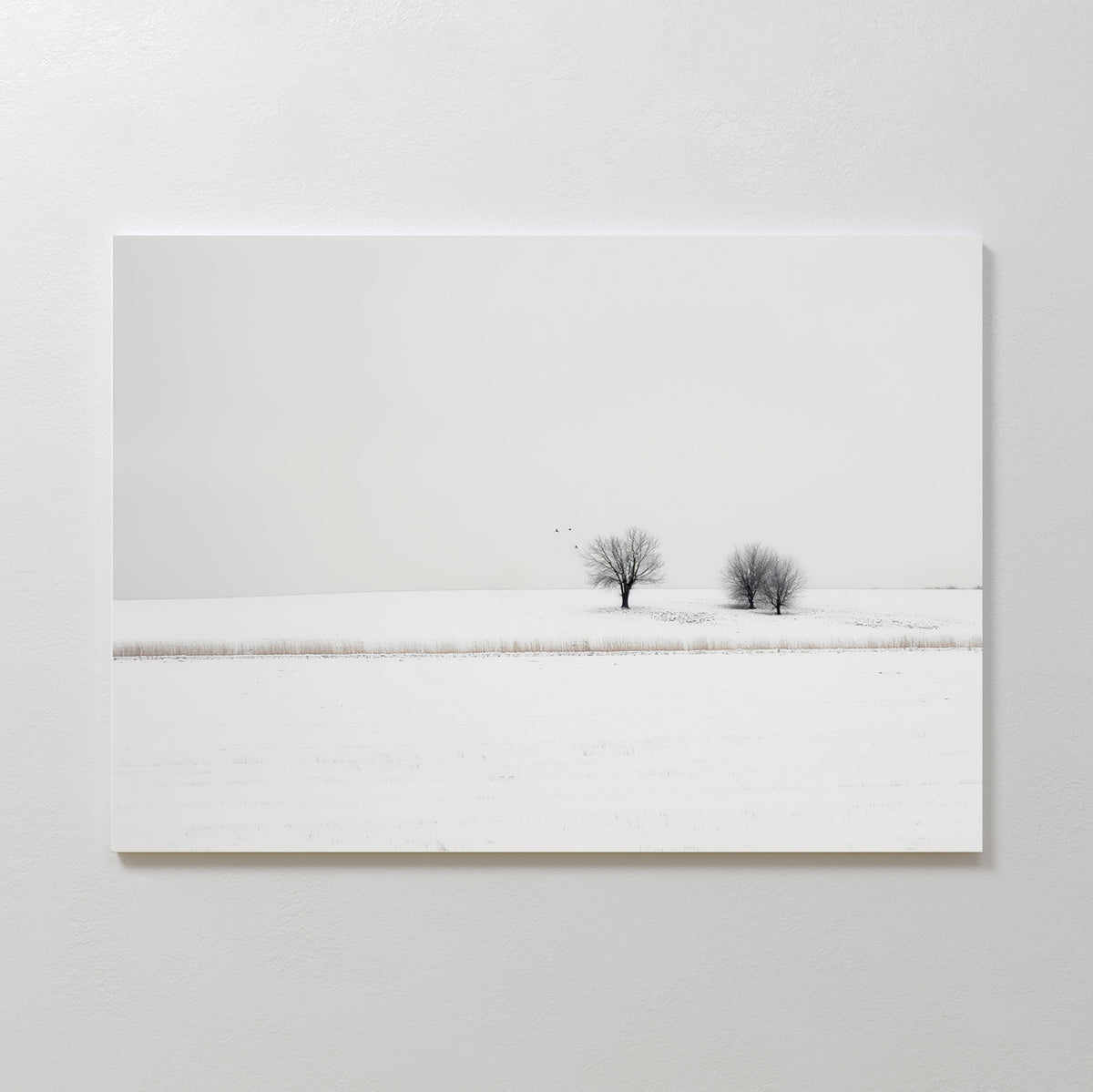 Winter Silence Canvas Art features a minimalist snow-covered landscape with two bare trees under a pale sky and three birds flying above—ideal for serene winter decor or elegant minimalist wall art.