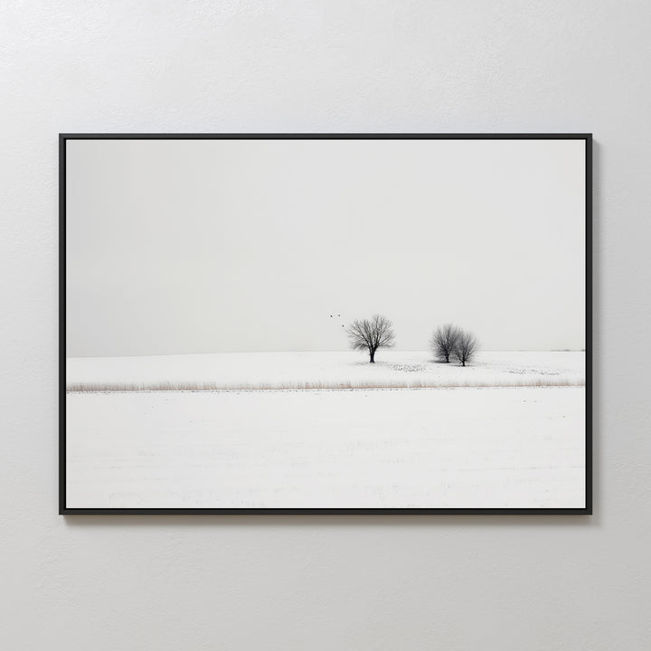 Winter Silence Canvas Art captures a minimalist snow-covered landscape with two leafless trees and three birds beneath a pale sky. This serene scene, framed simply, makes perfect minimalist wall art for any space.