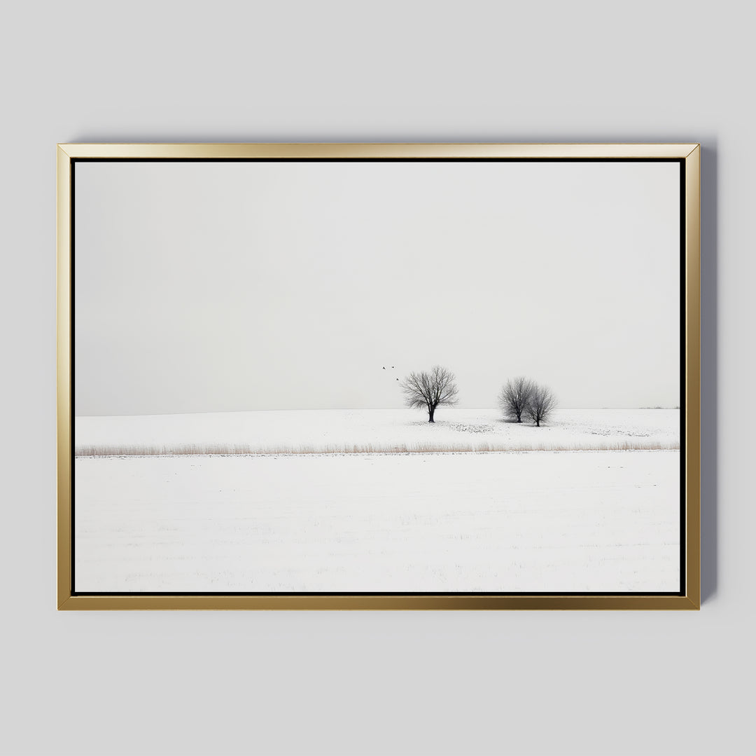 Winter Silence Canvas Art features a snow-covered landscape with two bare trees under an overcast sky and three birds in flight, creating minimalist wall decor that adds serene winter charm to any room.