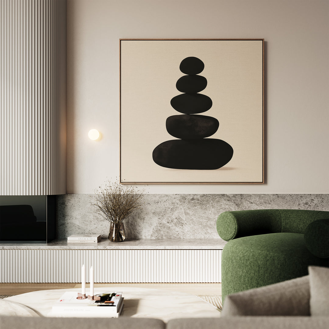 A modern living room with a green armchair, marble accents, a low table with books and candles, and the Zen Balance Canvas Art featuring stacked black stones above the sideboard—perfect for minimalist decor.