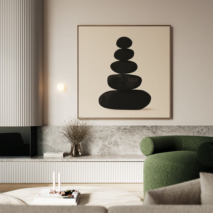 A modern living room with a green armchair, marble accents, a low table with books and candles, and the Zen Balance Canvas Art featuring stacked black stones above the sideboard—perfect for minimalist decor.
