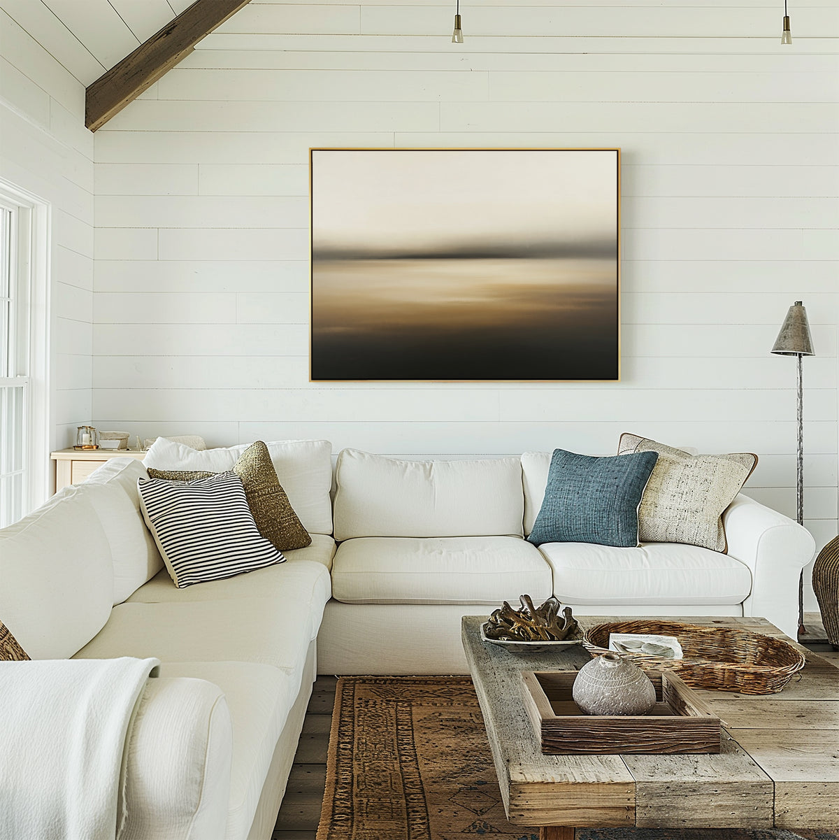 A bright, cozy living room with a white sectional sofa, assorted pillows, a wooden coffee table with decor, and the Amber Fields Canvas Art - Horizontal adding warmth to the white shiplap wall. Natural light fills the space.