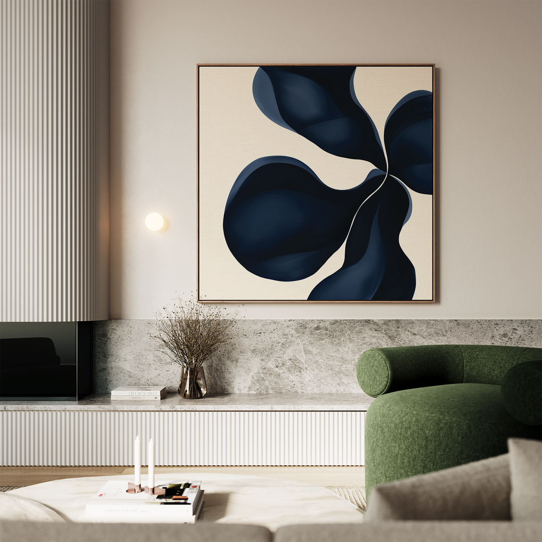 A modern living room with a green armchair, marble coffee table, minimalist decor, and the Blossom Blue Abstract Canvas Art featuring dark blue organic shapes on a beige background hanging on the wall.