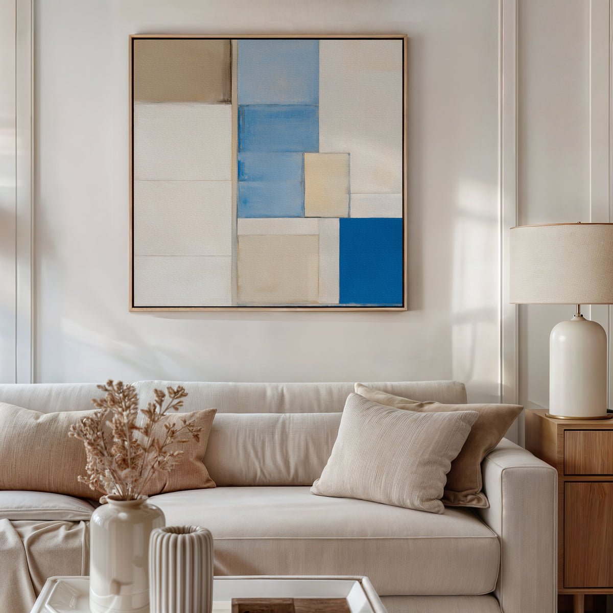 A beige sofa, neutral cushions, lamp on a side table, dried flowers in a vase, and the Blue Tiles Composition Canvas Art - Square add stylish flair to your modern living room decor.