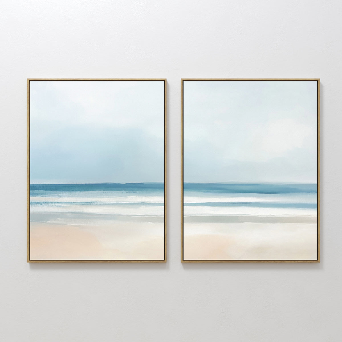The "Blurred Beach Scene - Set of 2" features minimalist, abstract framed prints side by side, capturing tranquil blue skies, gentle ocean waves, and sandy shores—ideal coastal wall art for serene decor settings.