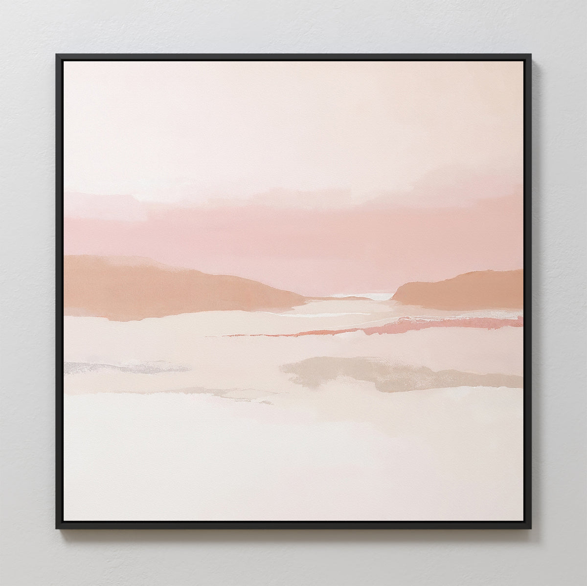 The Blush Mesa Canvas Art - Square is a minimalist wall piece featuring soft pastel earth tones of pink, peach, and beige in abstract hills under a calm sky, framed in black and displayed on a light-colored wall.