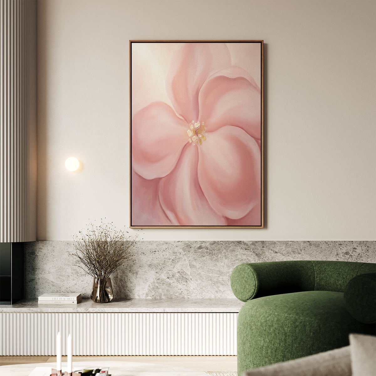 A living room featuring the Blushing Magnolia Canvas Art - Vertical, a green curved sofa, a vase with dried branches on a marble shelf, and neutral décor in earthy tones creates a softly romantic atmosphere.