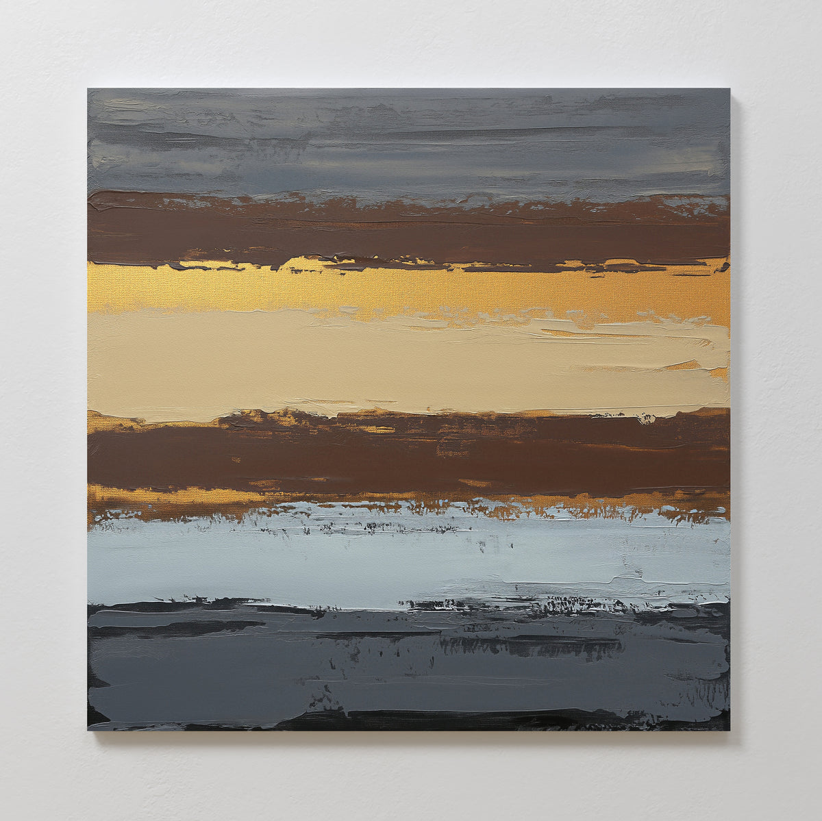 The Coastal Strata Canvas Art - Square features abstract horizontal layers in gray, blue, brown, and gold, creating an earthy, sophisticated look with a textured landscape effect on a square canvas displayed against a white wall.